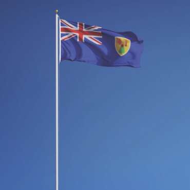 Turks and Caicos Islands flag waving against clean blue sky, long shot, isolated with clipping path mask alpha channel transparency
