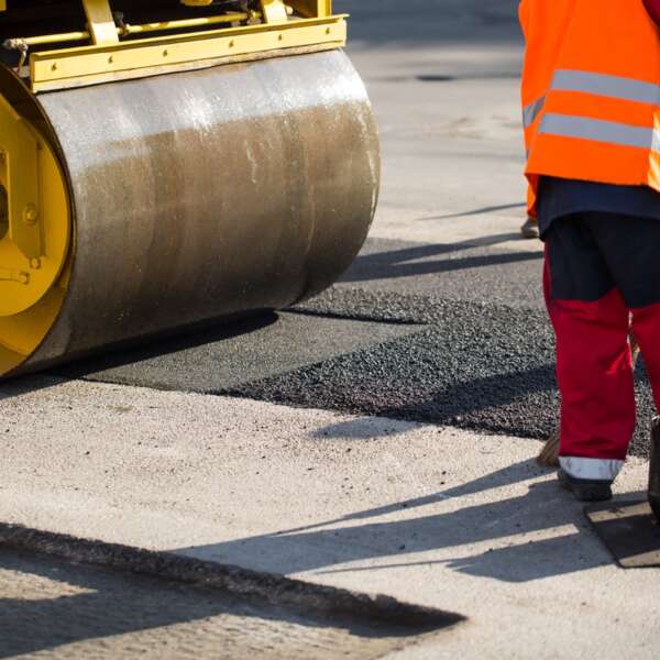 Road repairs. A road roller compacting asphalt